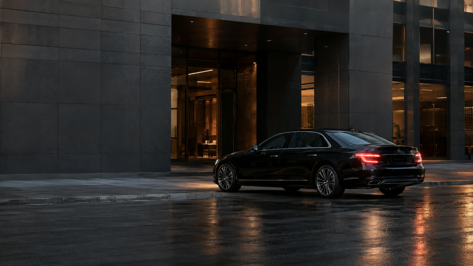 Black executive limousine waiting outside a contemporary office building.